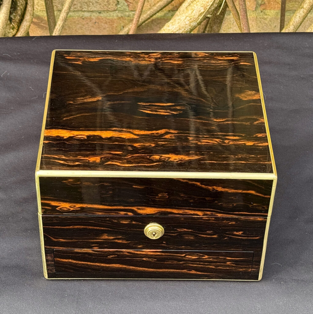 Overhead view of a rare miniature antique jewellery box in coromandel, by George Betjemann & Sons.