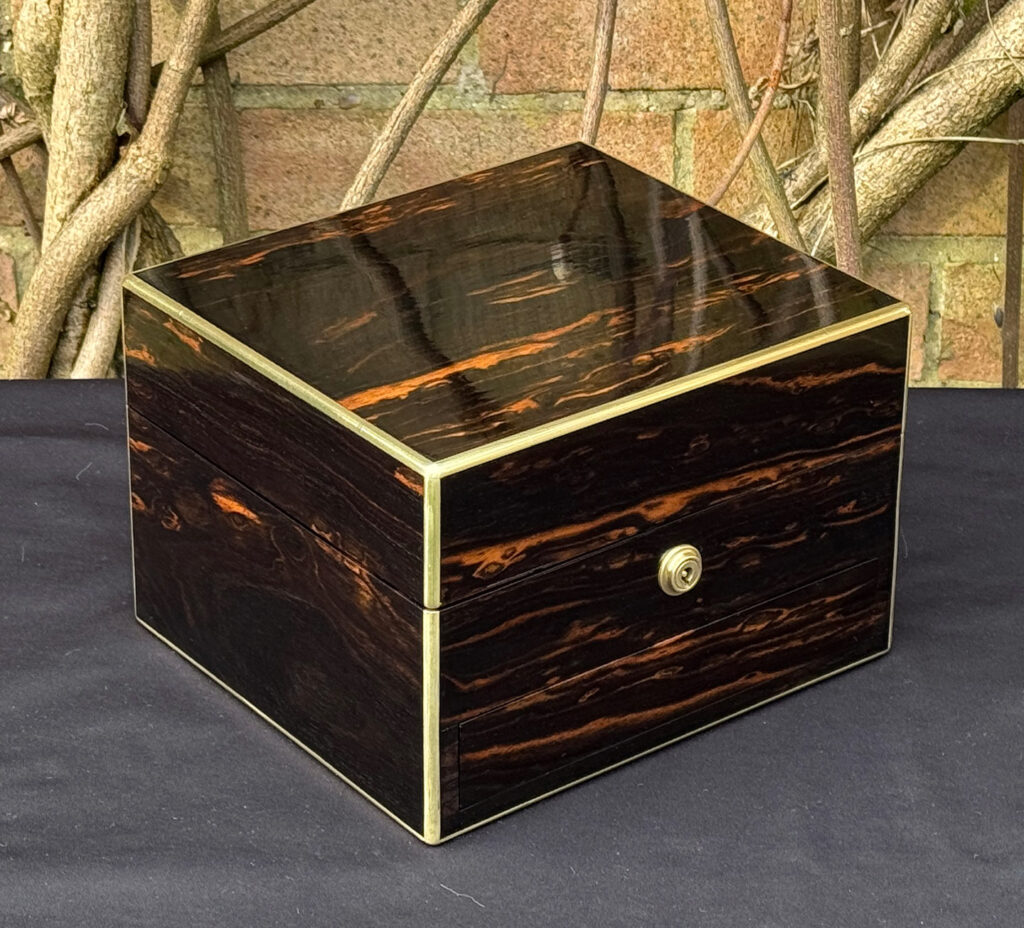 Front left view of a rare miniature antique jewellery box in coromandel, by George Betjemann & Sons.