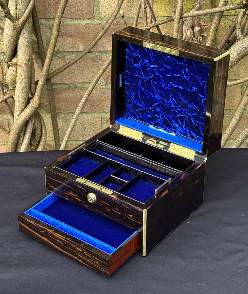 Front right interior view of a rare miniature antique jewellery box in coromandel, by George Betjemann & Sons, with lower drawer opened.