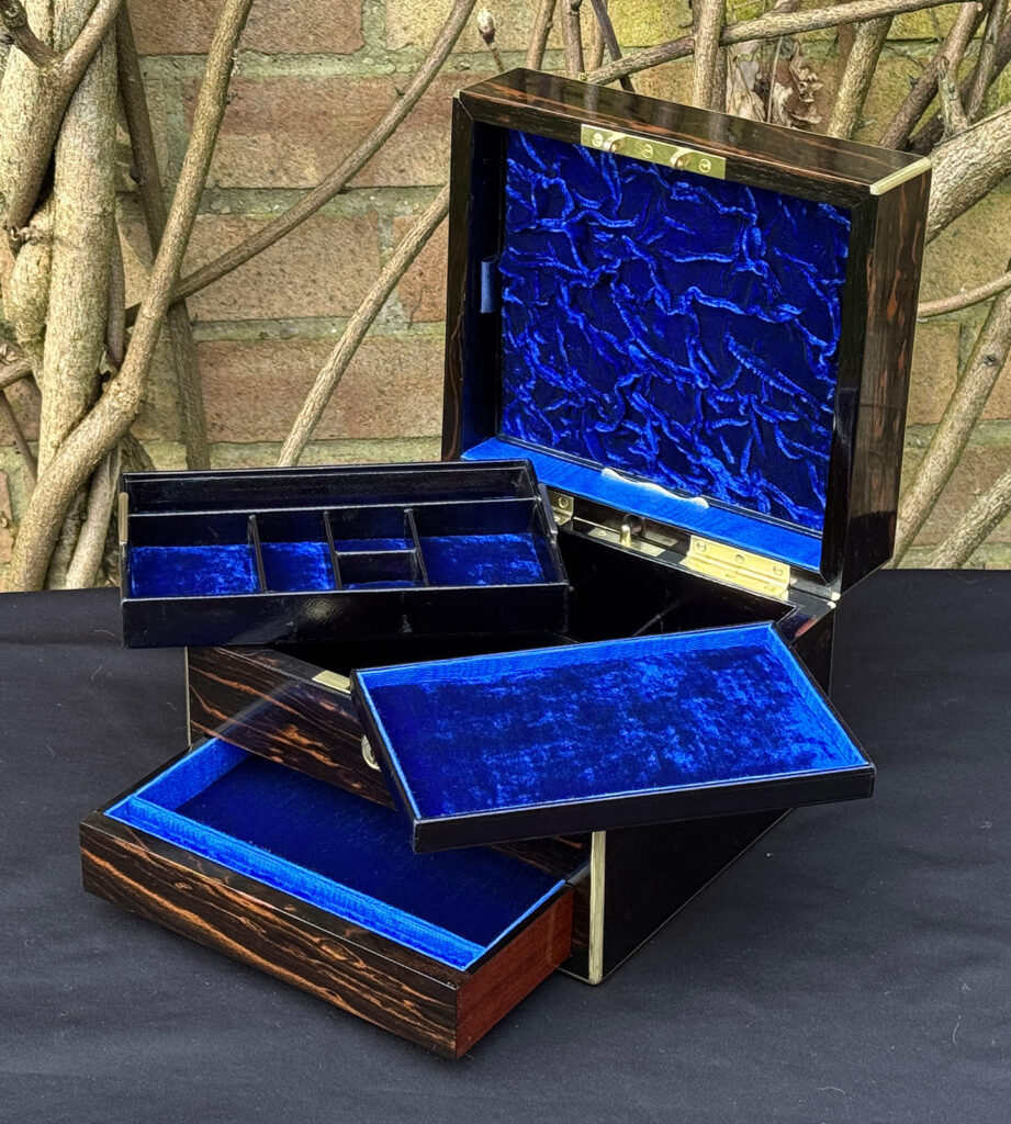 Front right interior view of a rare miniature antique jewellery box in coromandel, by George Betjemann & Sons, with both trays removed.