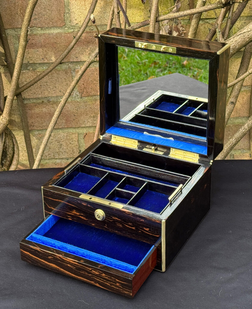 Front right interior view of a rare miniature antique jewellery box in coromandel, by George Betjemann & Sons, with mirror on display.