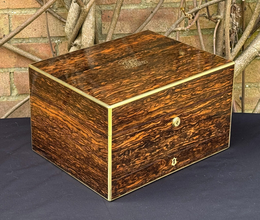 Front left view of an antique jewellery box in coromandel by Halstaff & Hannaford.
