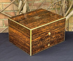 Front left view of an antique jewellery box in coromandel by Halstaff & Hannaford.