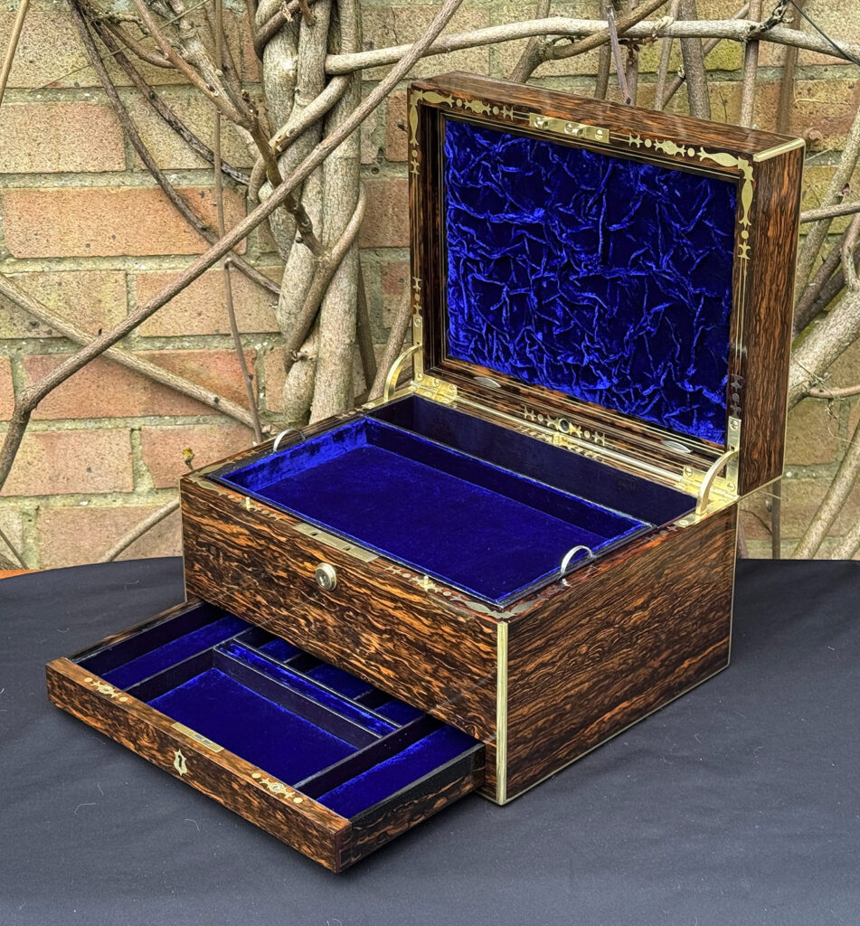 Front right interior view of an antique jewellery box in coromandel by Halstaff & Hannaford, with lower drawer open.
