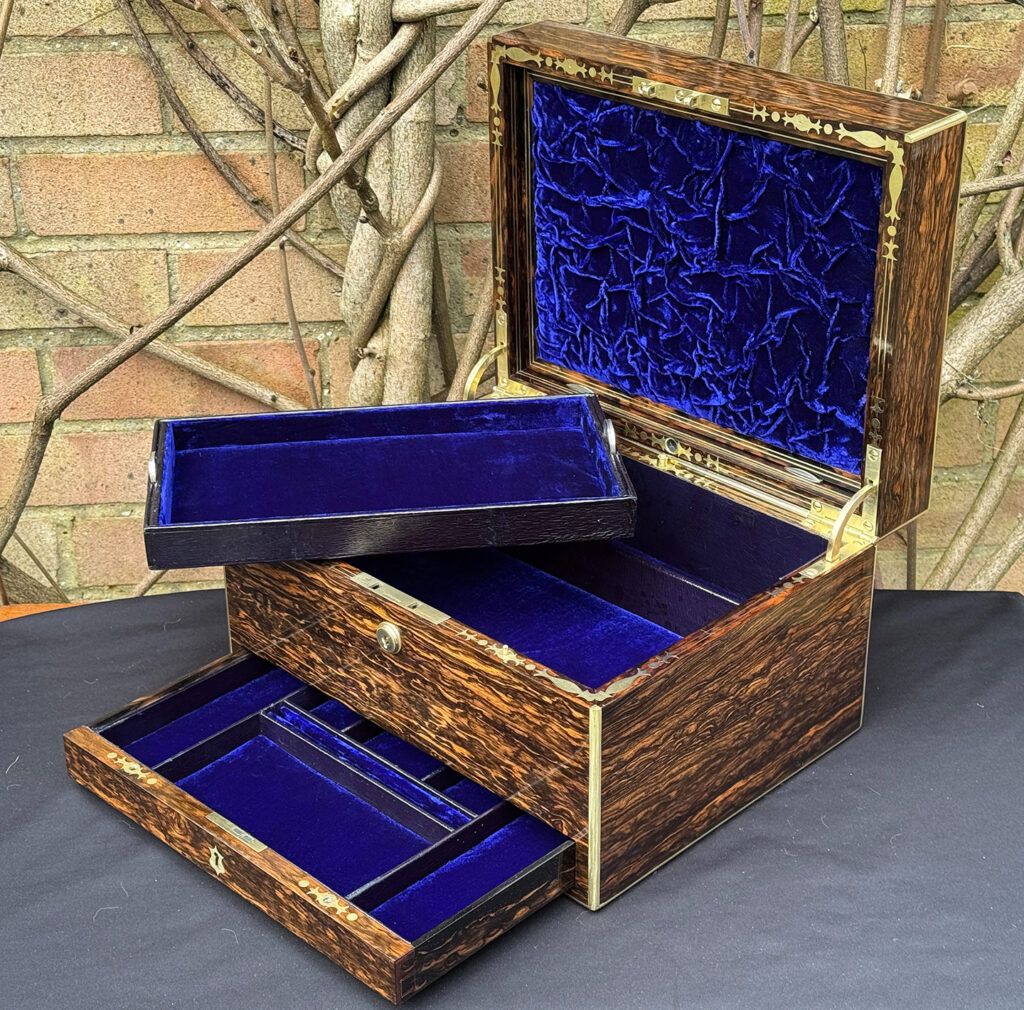 Front right interior view of an antique jewellery box in coromandel by Halstaff & Hannaford. with tray removed.