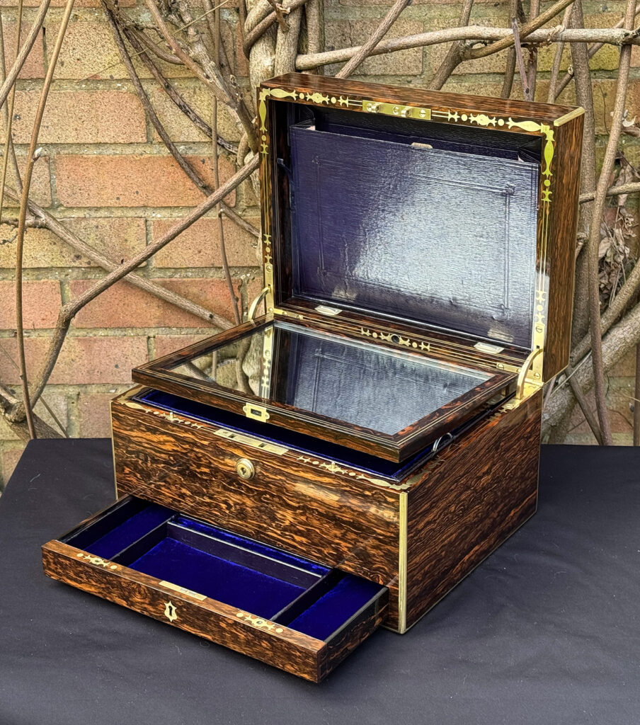 Front right interior view of an antique jewellery box in coromandel by Halstaff & Hannaford. with mirror frame removed.