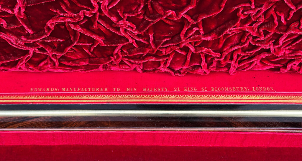 Close up view of the Edwards manufacturer mark in gold tooling.