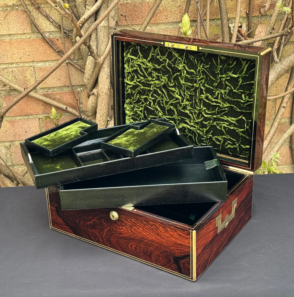 Front right interior view of an antique jewellery box in rosewood, by Edwards, with both trays removed.