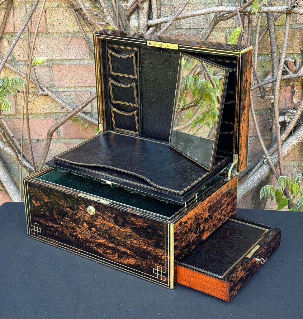 Front right interior view of an antique jewellery box in coromandel, by William Lund, with letter wallet, stamp wallets, and mirror on view.
