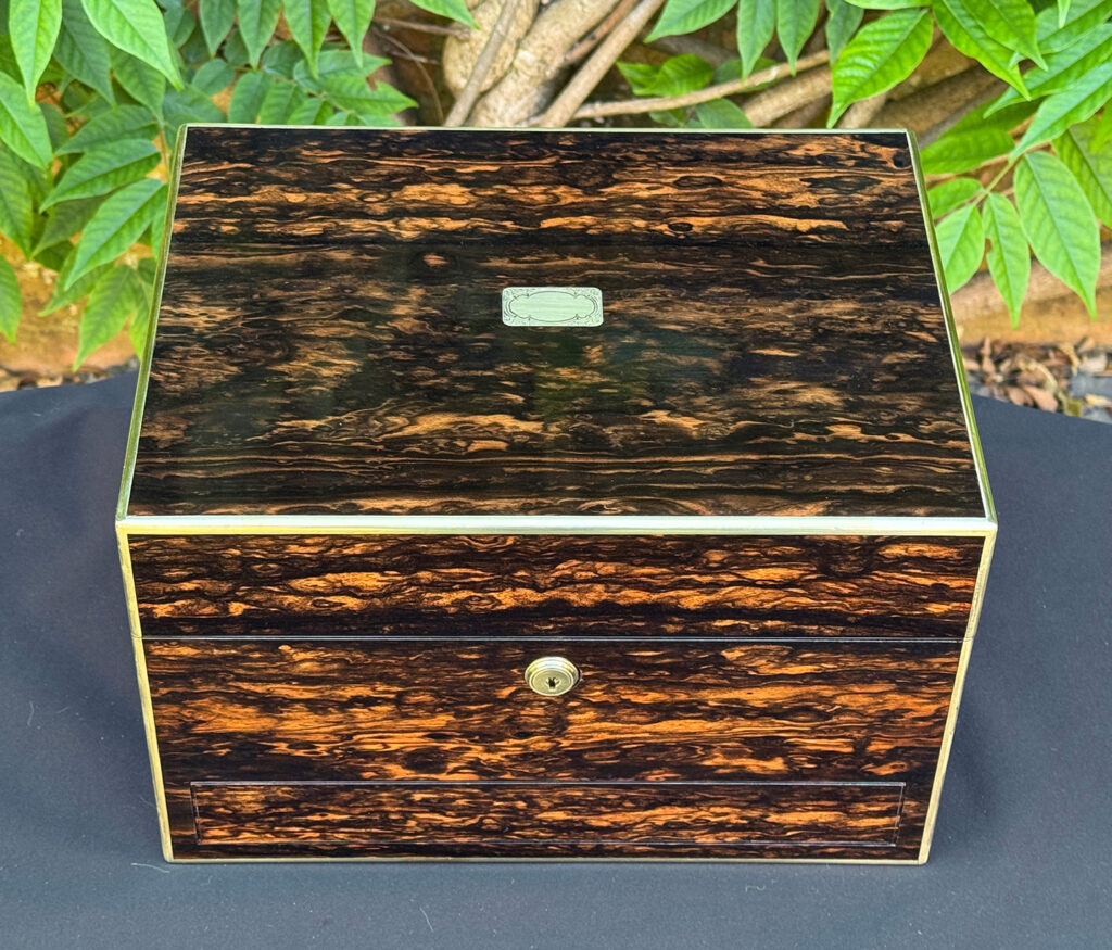 Overhead view of an antique jewellery box in coromandel with front & side drawer.