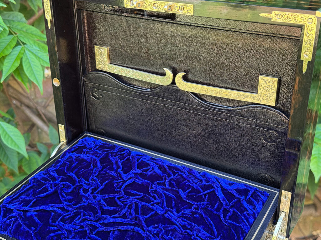 Closer view of the engraved brass mirror brackets in their closed position.