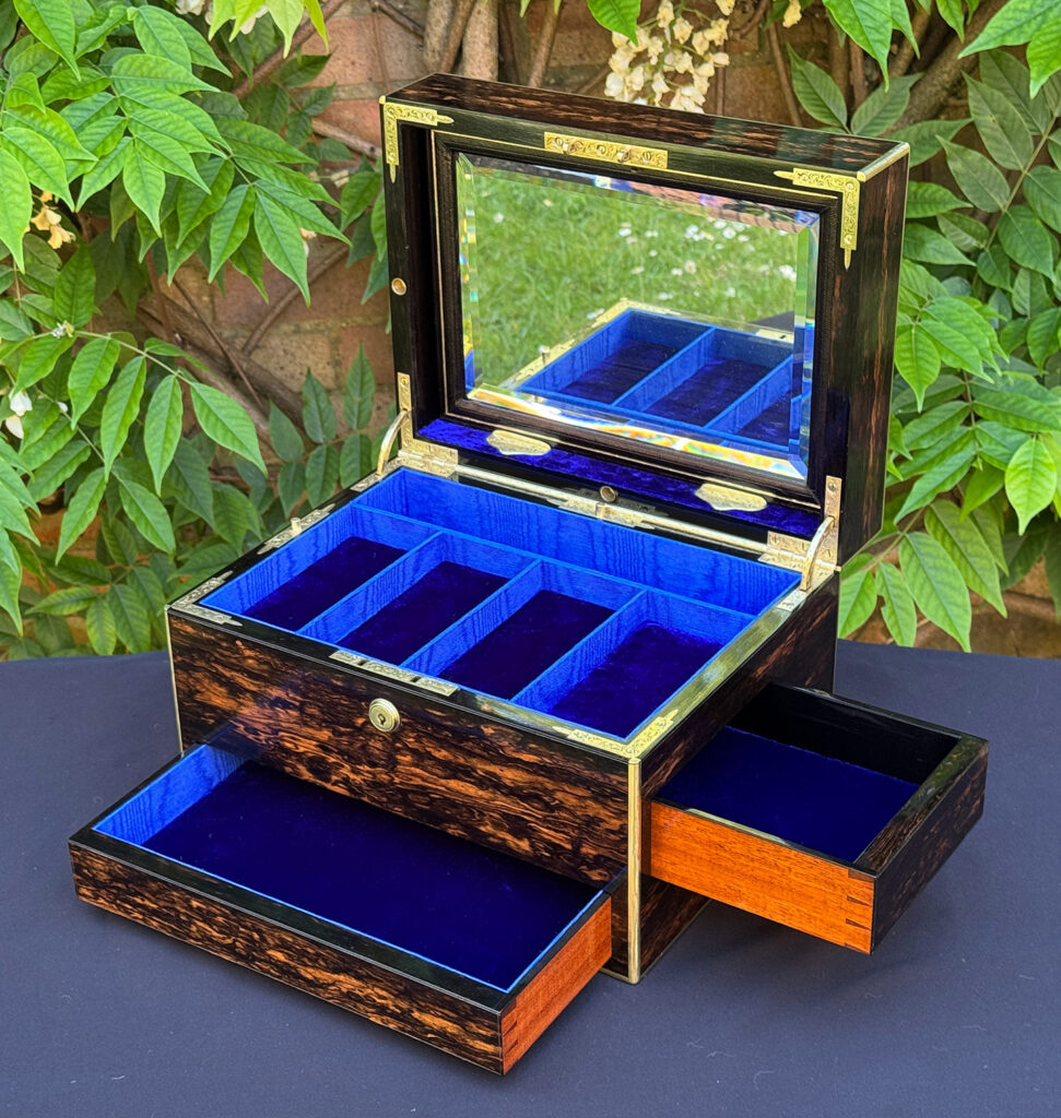 Front right interior view of an antique jewellery box in coromandel with front & side drawer, with both drawers opened and mirror panel on display.