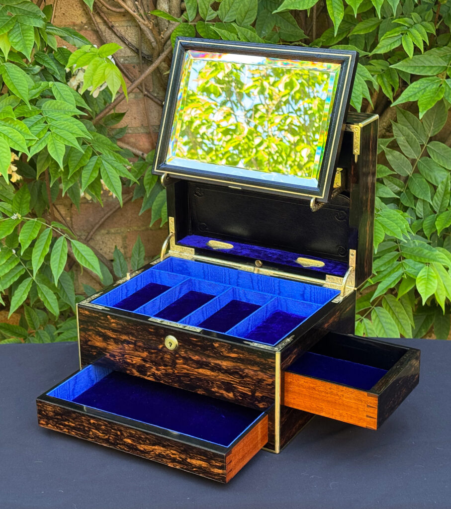 Front right interior view of an antique jewellery box in coromandel with front & side drawer, with both drawers opened and mirror panel on its brackets.
