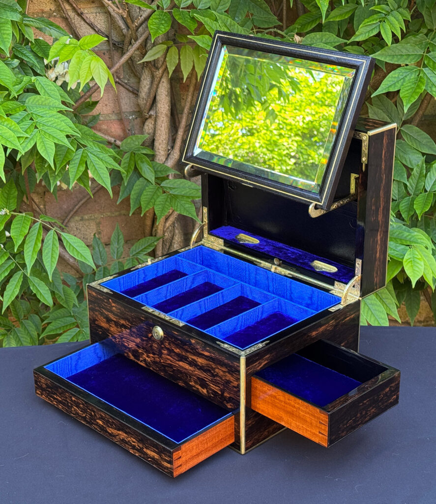 Front right interior view of an antique jewellery box in coromandel with front & side drawer, with both drawers opened and mirror panel on its brackets.