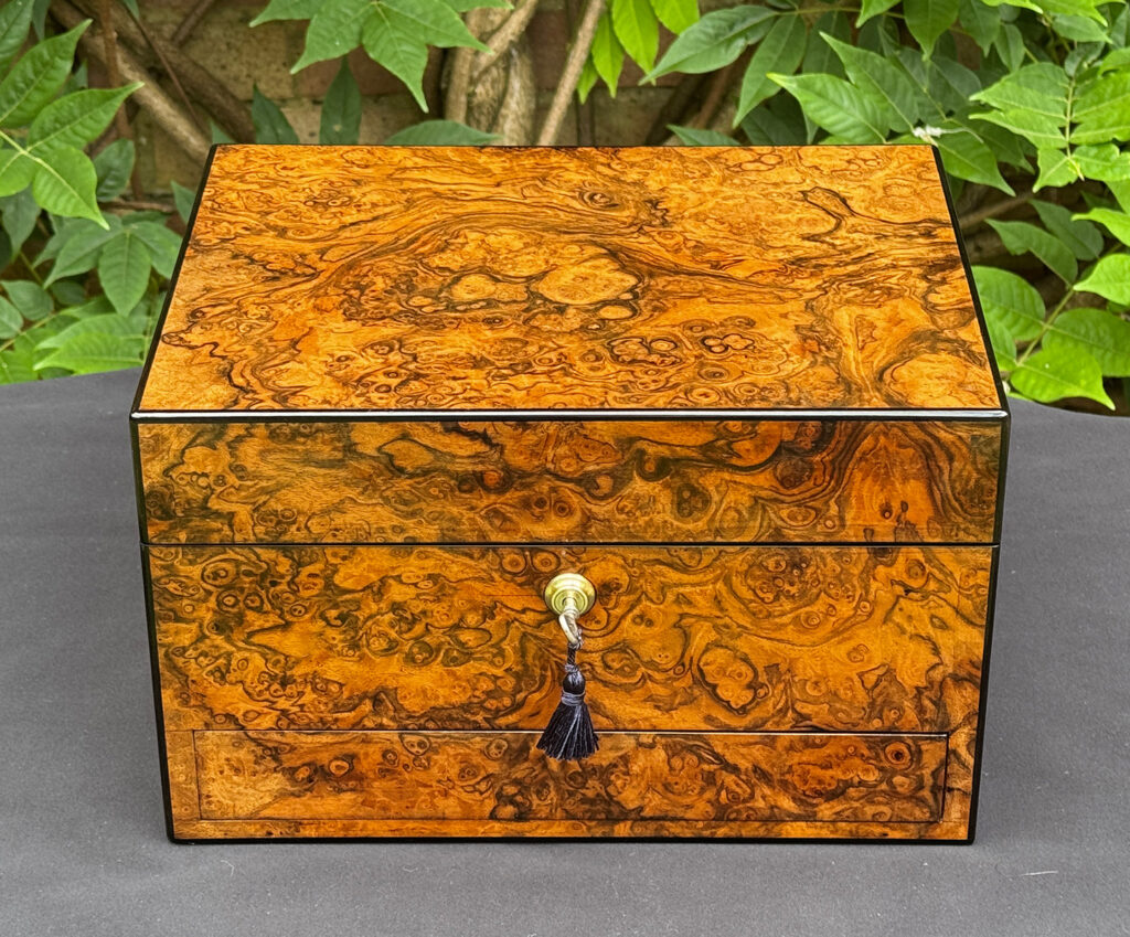 Front view of an antique jewellery box in burr walnut, by George Betjemann & Sons.