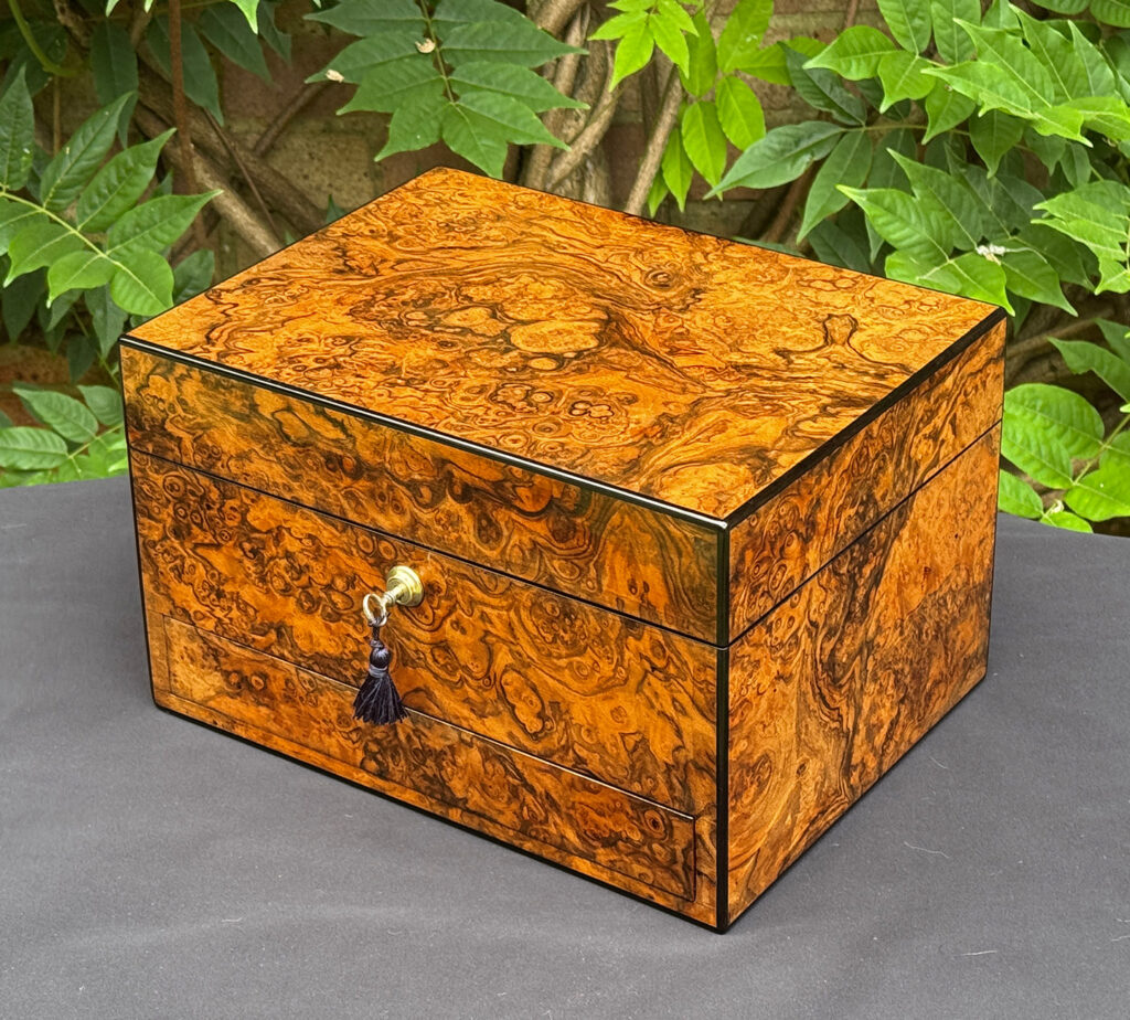 Front right view of an antique jewellery box in burr walnut, by George Betjemann & Sons.