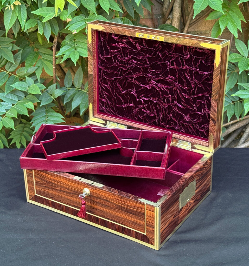 Front right interior view of an antique jewellery box in kingwood, by David Edwards, with top trays removed.
